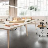 bureau bench 4 postes de travail blanc avec pieds en bois dans un open space avec des chaises ergonomiques jaune