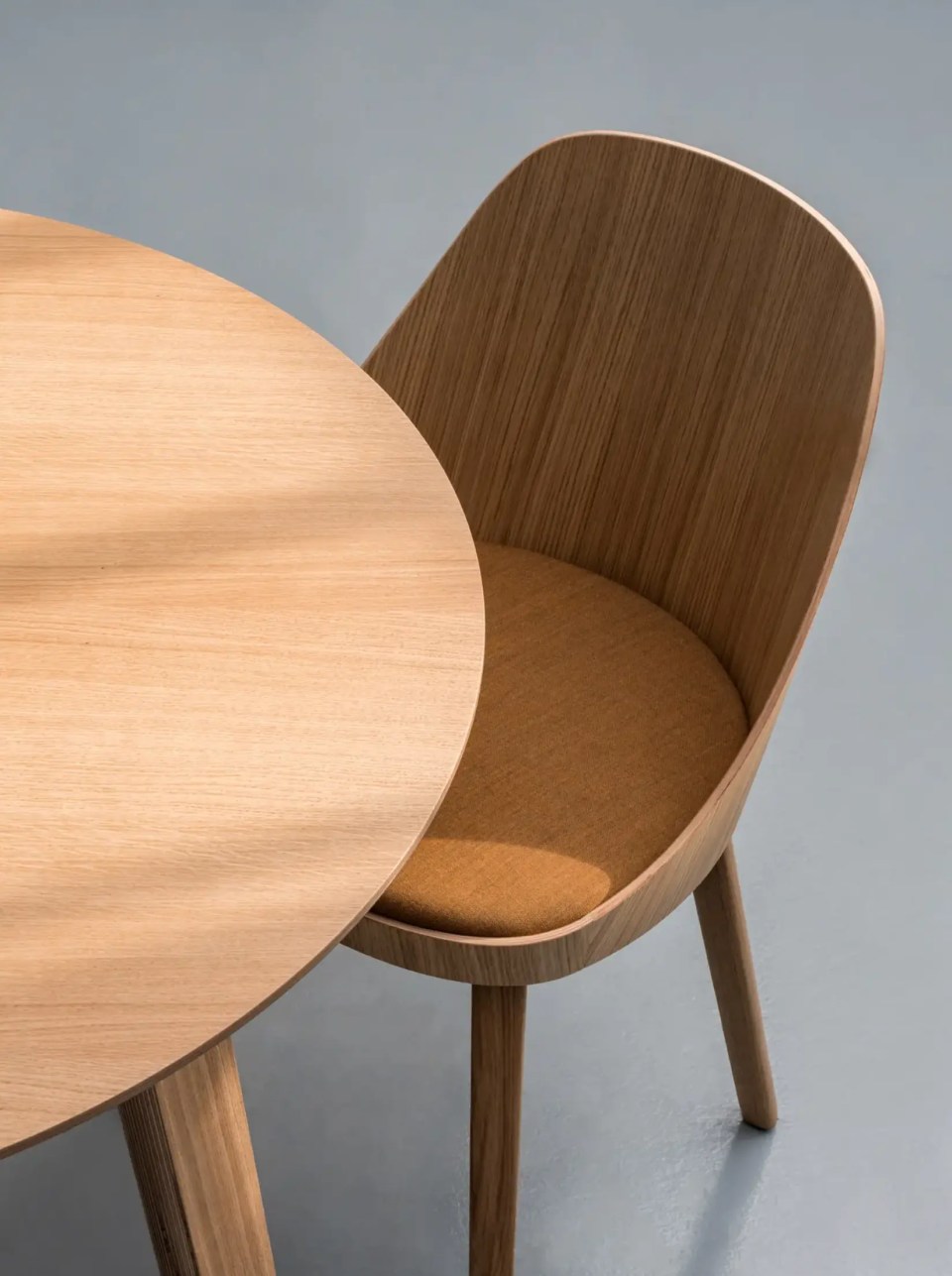 chaise en bois de cafétéria et restaurant avec dossier bois et assise noire dossier tapissé beige avec table chêne ronde