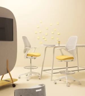 chaises de bureau télétravail jaune et tabouret haut de bureau dans un open space avec bureaux bench et panneau acoustique mobile