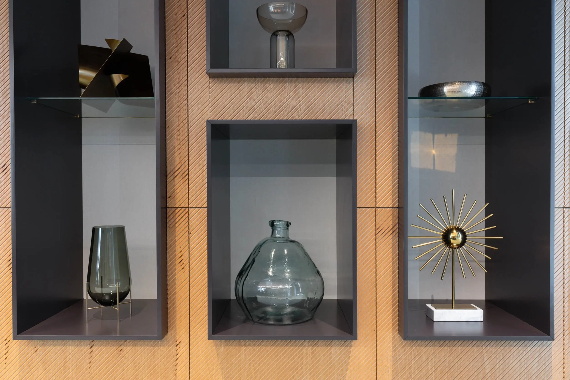 a shelf with glass vase and other objects on it