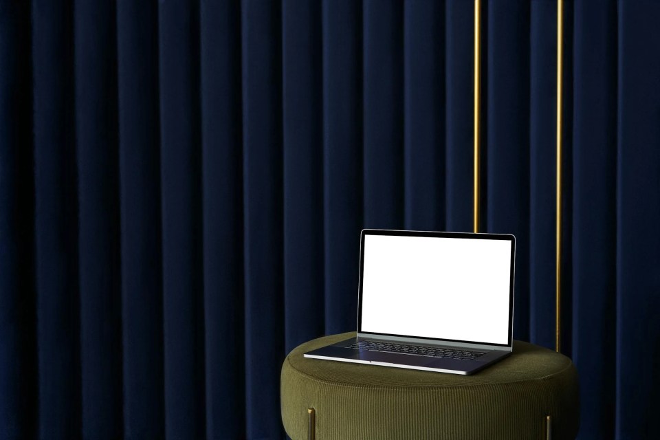rideau acoustique bleu profond avec un pouf design et un ordinateur laptop