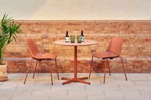 table ronde rouge sur une terrasse et fauteuils dans un bar ou salon de thé design